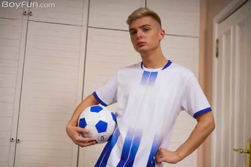 Cute football boy getting naked