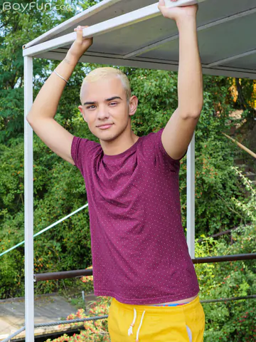 Blonde boy getting naked outdoors