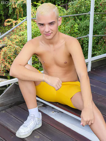 Blonde boy getting naked outdoors