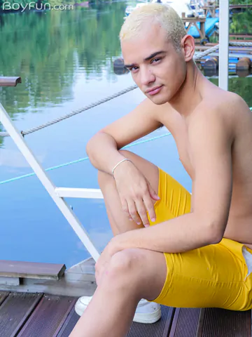 Blonde boy getting naked outdoors