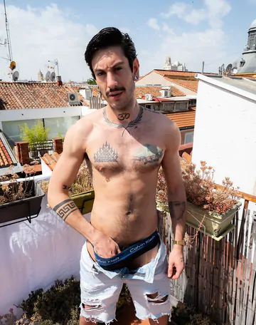 Tattooed guy wanking on a rooftop
