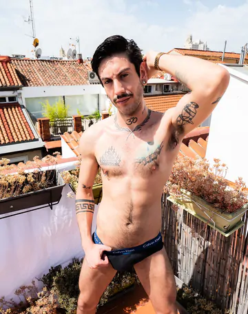 Tattooed guy wanking on a rooftop