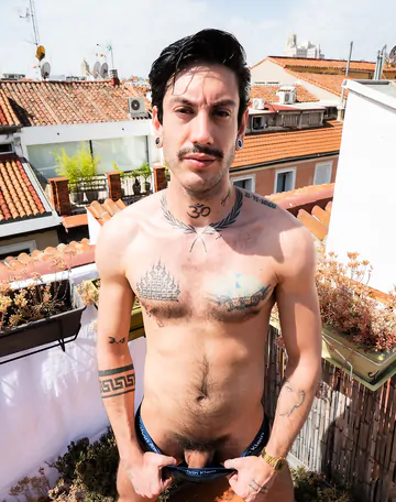 Tattooed guy wanking on a rooftop