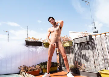 Tattooed guy wanking on a rooftop