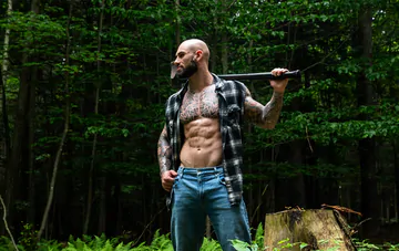 Tattooed hunk wanking in the forest