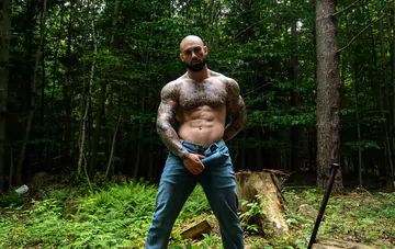 Tattooed hunk wanking in the forest