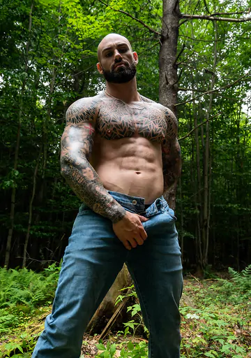 Tattooed hunk wanking in the forest