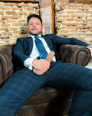 Man in a suit takes his dick out